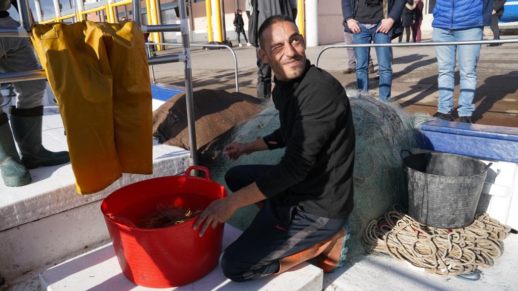 El pescador Gerard Mars junto a un barreño con los organismos capturados accidentalmente.