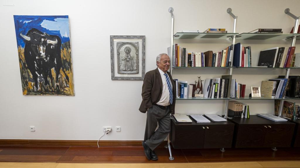 Gonzalo Santonja, en su despacho flanqueado de un lado por sus amados libros y, de otro, por una pintura de un toro y su venerada Virgen del Castañar