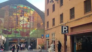 Imagen de la entrada del aparcamiento subastado por el Gobierno central y, al lado, el Mercado de Atarazanas de Málaga.