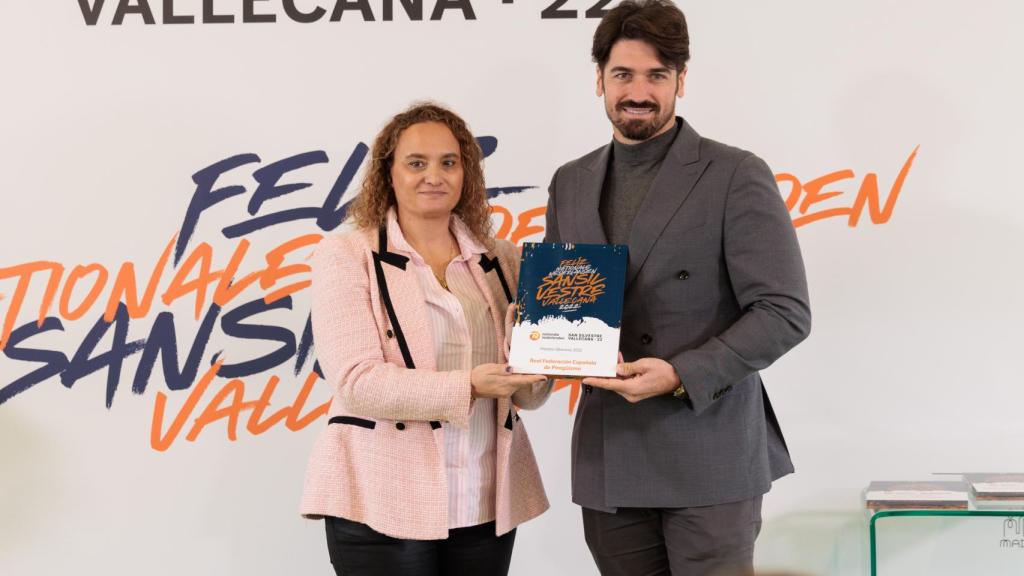 La directora de la San Silvestre Vallecana, Patricia Sabugueiro, entrega el premio a la Real Federación Española de Piragüismo, recogido por su presidente, Javier Hernanz