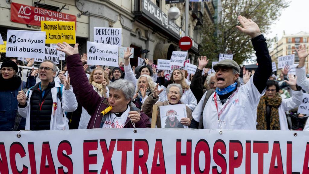 Médicos y pediatras sostienen pancartas durante una manifestación.