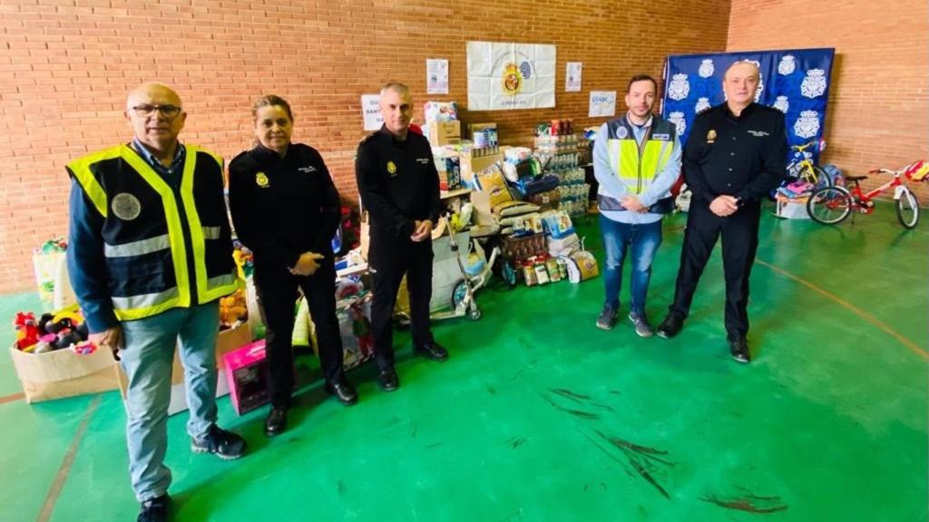 Policías muestran una parte de los alimentos y juguetes recogidos en Málaga.