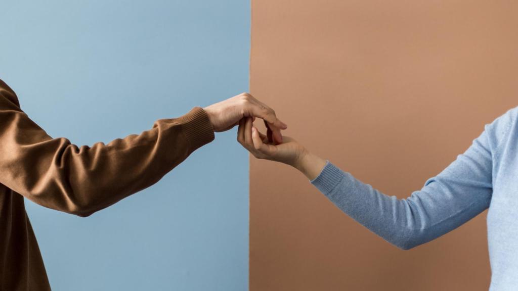 Una pareja, dándose la mano.