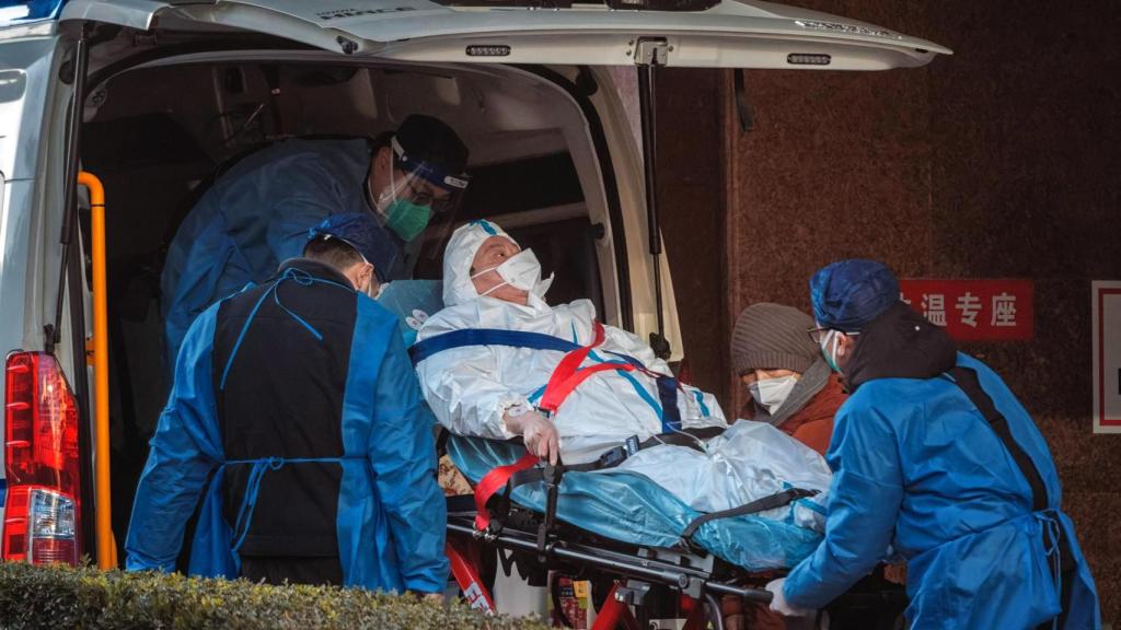 Trabajadores sanitarios trasladan a una persona al hospital en Shanghái, China.