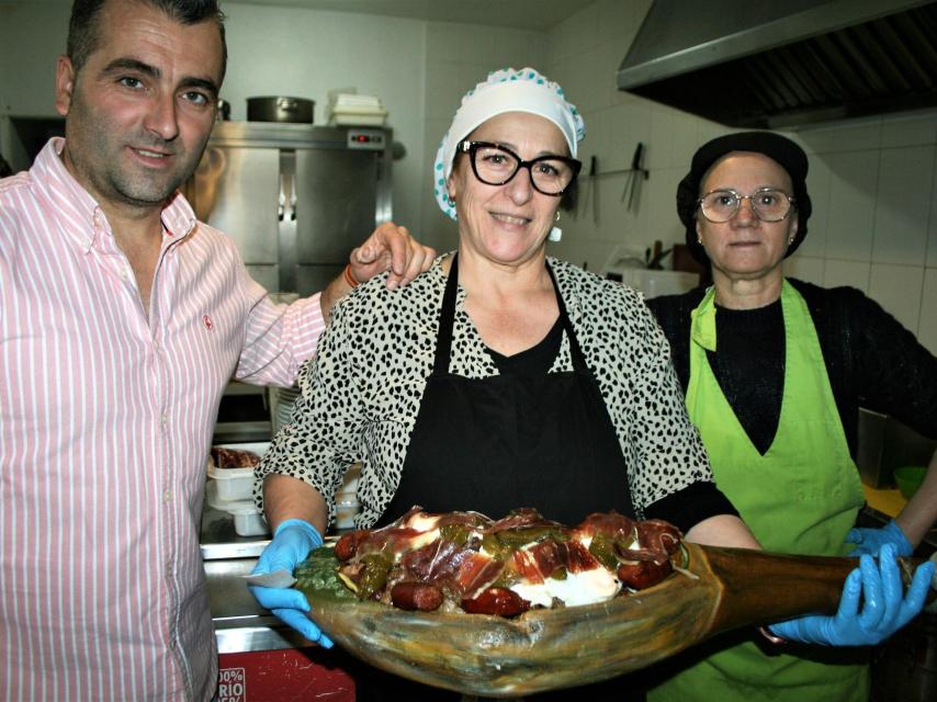 Juan Manuel Moya, inventor del 'volcán ibérico', y las cocineras Antonia Martín e Isidora Carmona enseñan uno recién terminado, en el Casino Serrano El Repilado.