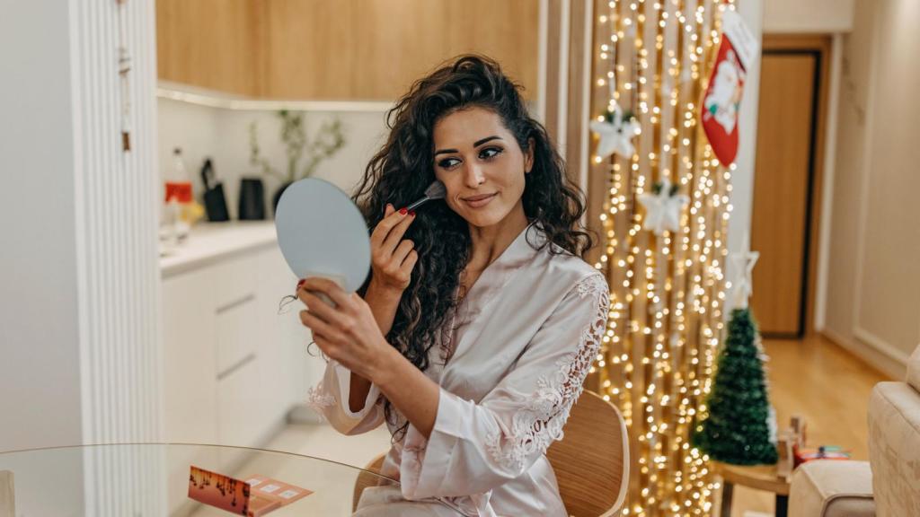 Una mujer, maquillándose.