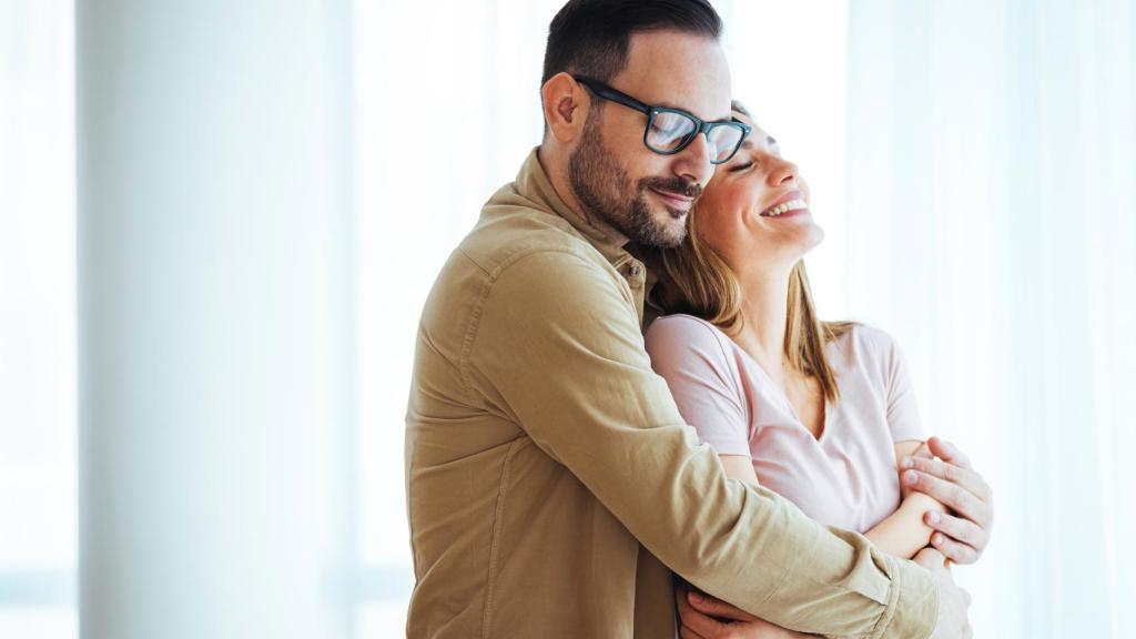 Una mujer abrazada por un hombre
