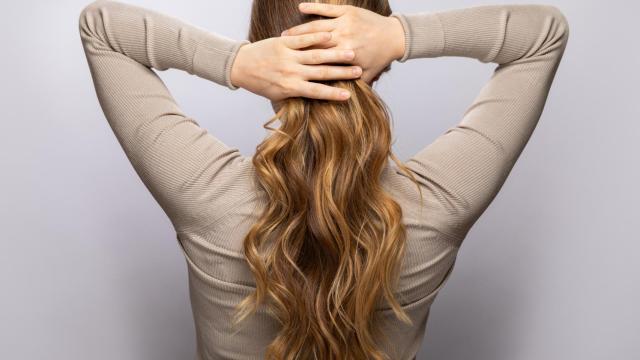Una mujer, sujetando su melena.