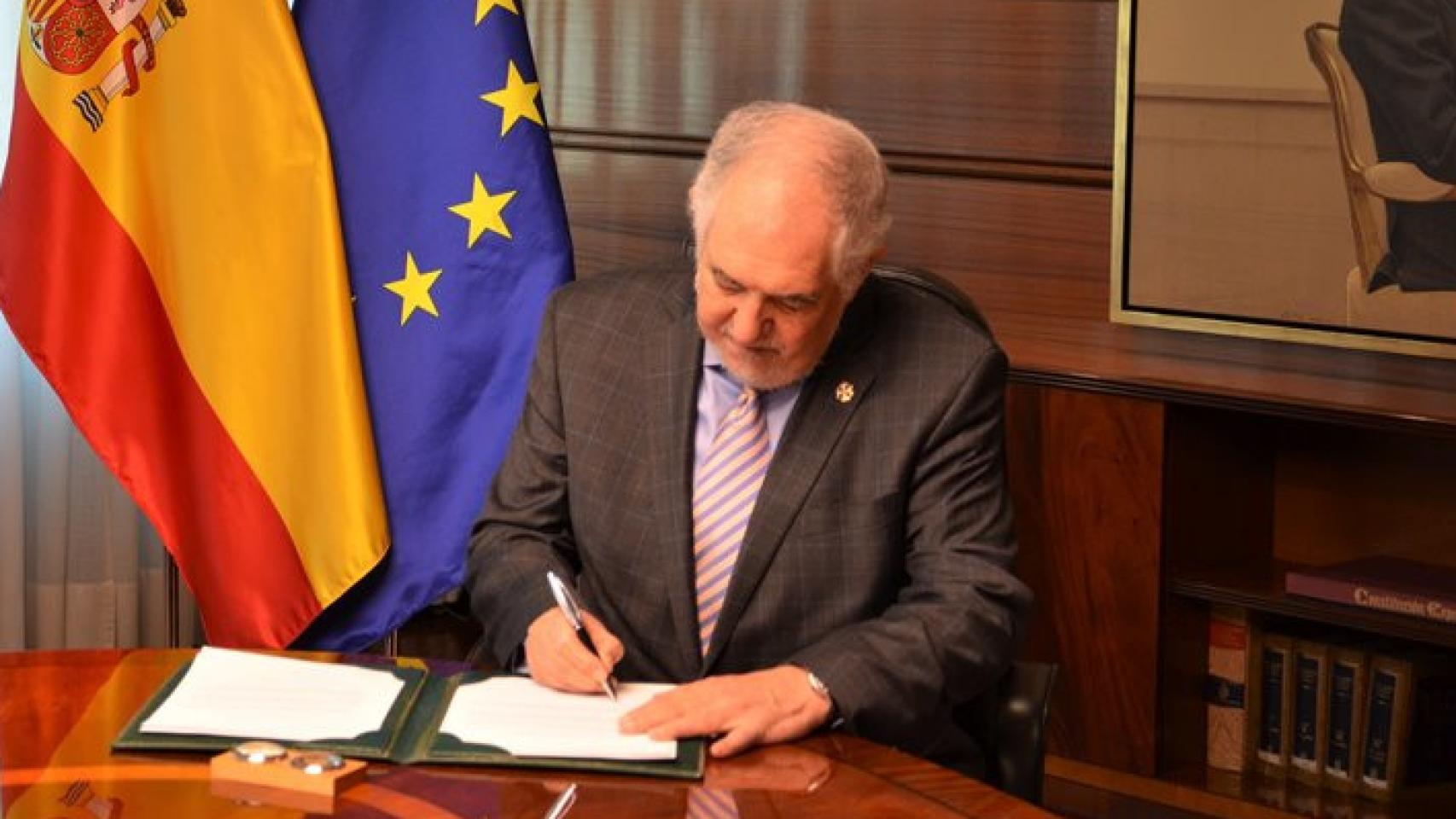 Conde-Pumpido firma su toma de posesión como presidente del TC. De pie, la vicepresidenta, Inmaculada Montalbán.