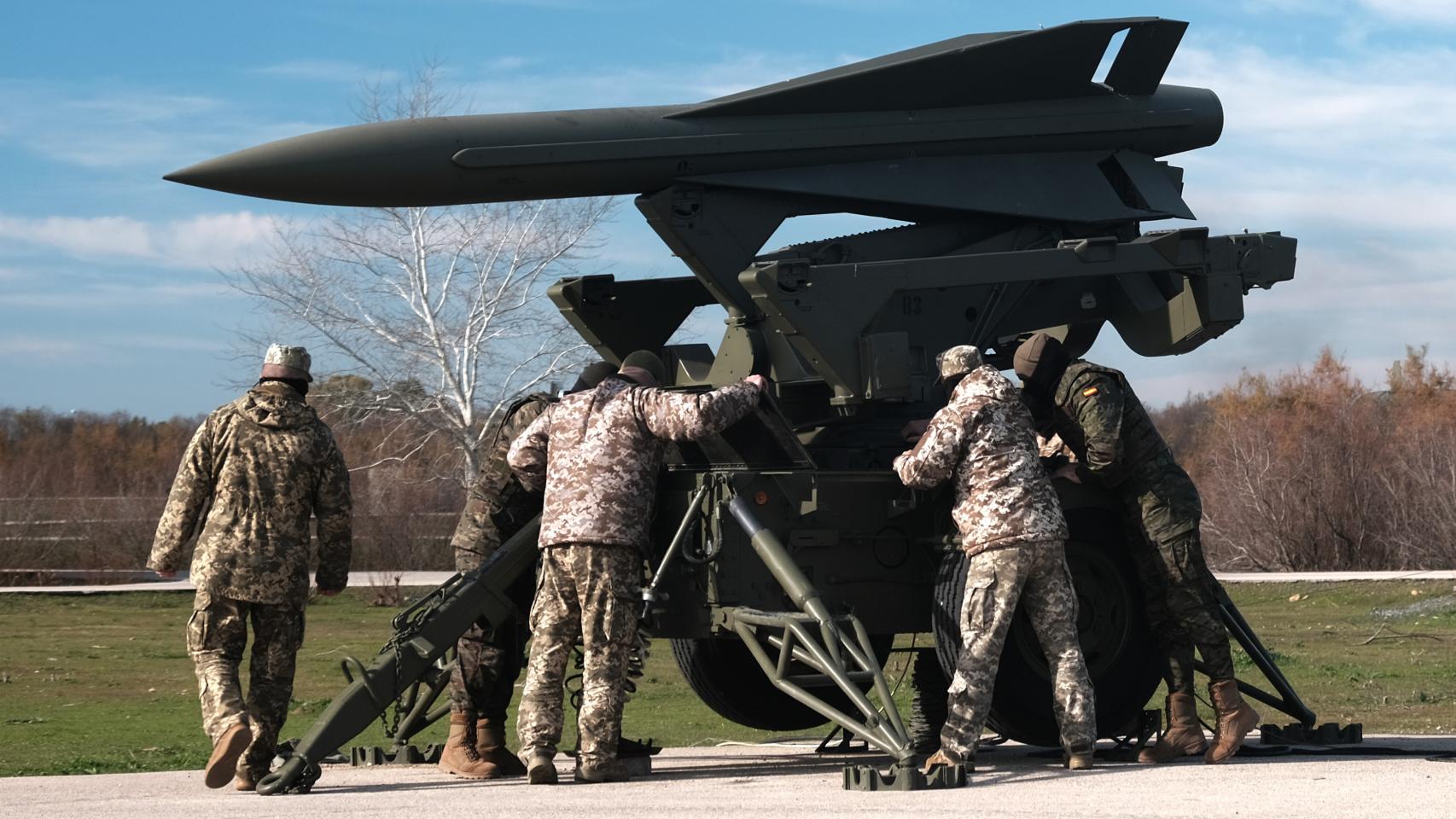 Militares ucranianos, con uniforme más claro, e instructores españoles manejan un lanzador de misiles antiaéreos Hawk, el 26 de enero en la base de El Copero, en la provincia de Sevilla.