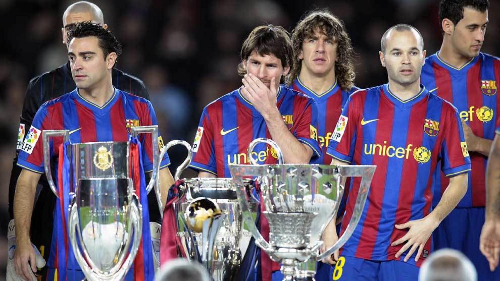 Xavi Hernández, Leo Messi y Andrés Iniesta posan detrás del triplete de títulos conseguido por el Barça de Guardiola en 2009.