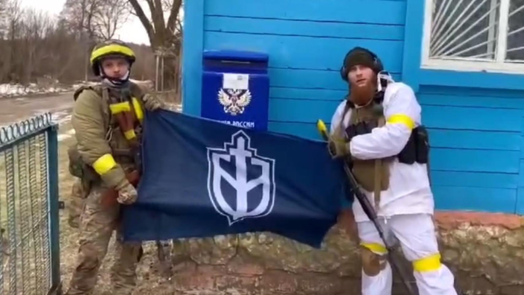 Los presuntos miembros del Cuerpo de Voluntarios Rusos de la Defensa Territorial de Ucrania posan junto a su bandera en el óblast de Briansk, Rusia, cerca de Ucrania el 2 de febrero de 2023.