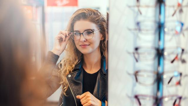Mujer probándose gafas en la óptica.