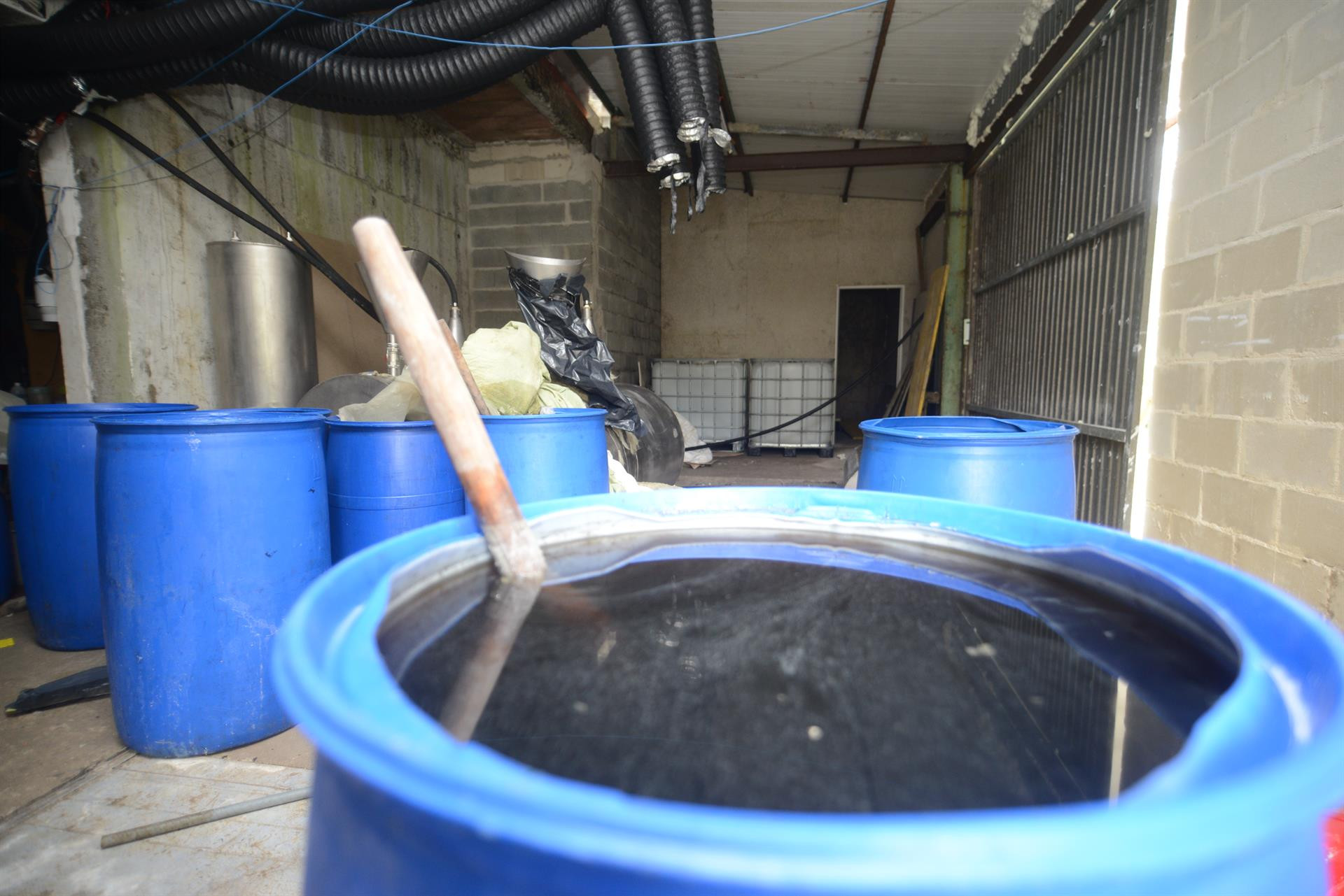 Bidones con disolvente en una vivienda donde se ha encontrado un laboratorio de cocaína en Cerdedo-Cotobade (Pontevedra). Foto: Gustavo de la Paz / EP