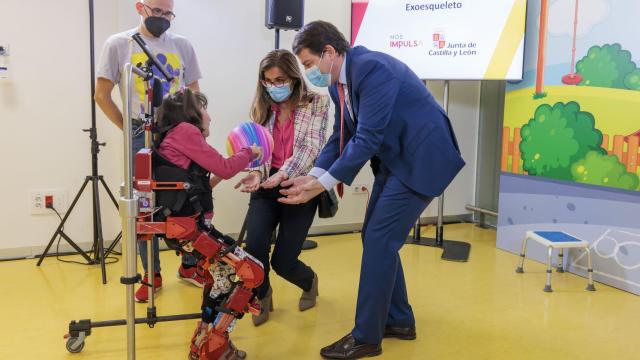 Lola con el exoesqueleto junto a sus padres y a Fernández Mañueco