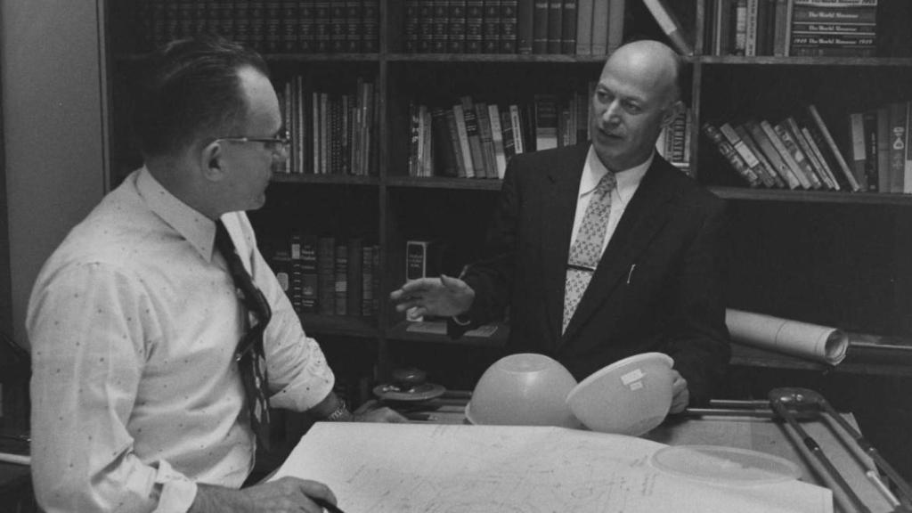 Earl Tupper, a la derecha, trajeado, junto a dos productos Tupperware.