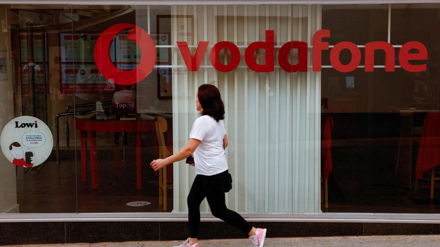 Una mujer pasa por delante de una tienda de Vodafone en Ronda (Málaga).