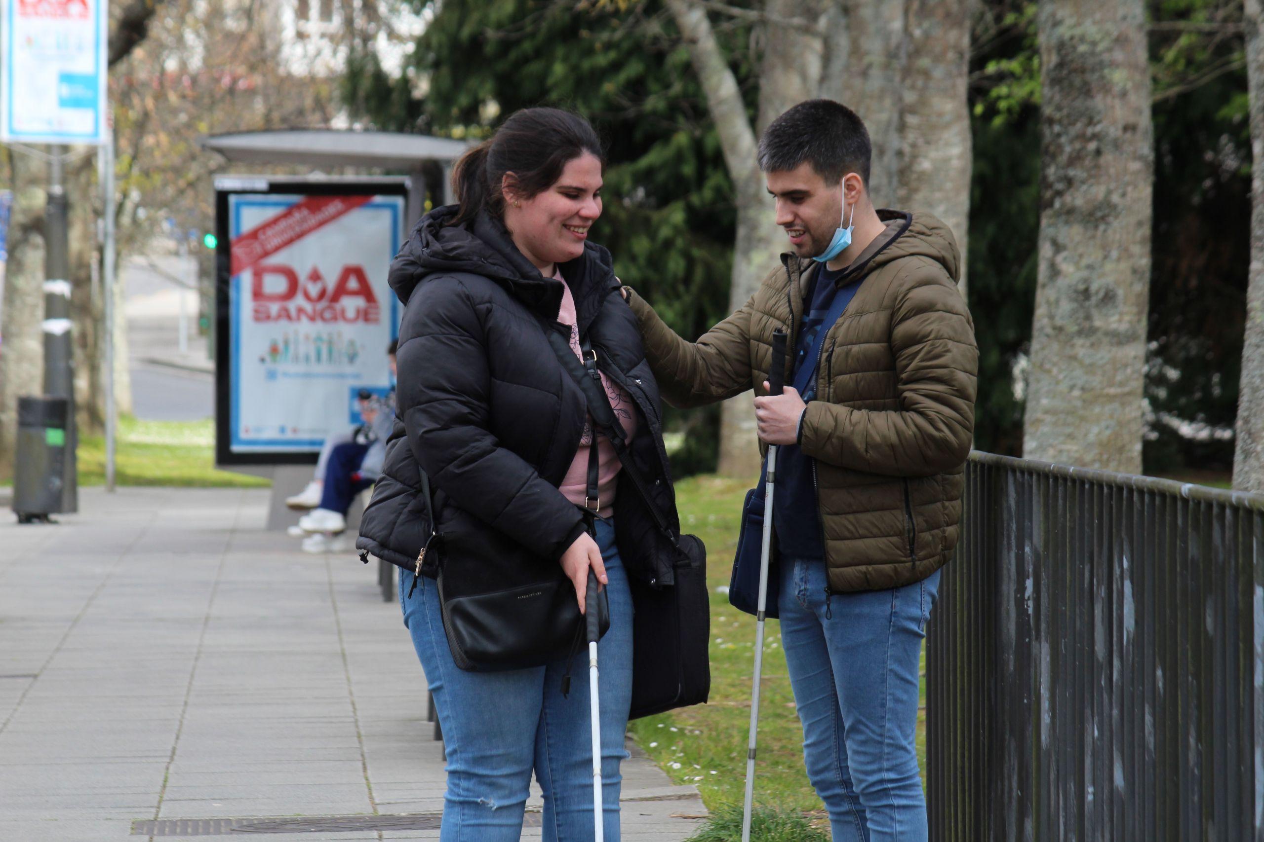 Dos vecinos en la parada de autobús del barrio de Vista Alegre