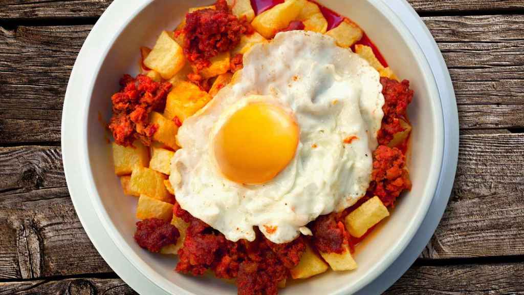 Un plato de huevos, chorizo y patatas fritas.