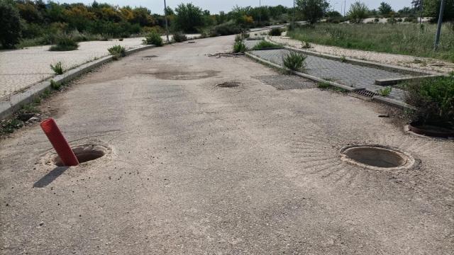 Varias alcantarillas descubiertas en una vía de la urbanización de Valdeluz, en el municipio de Guadalajara.
