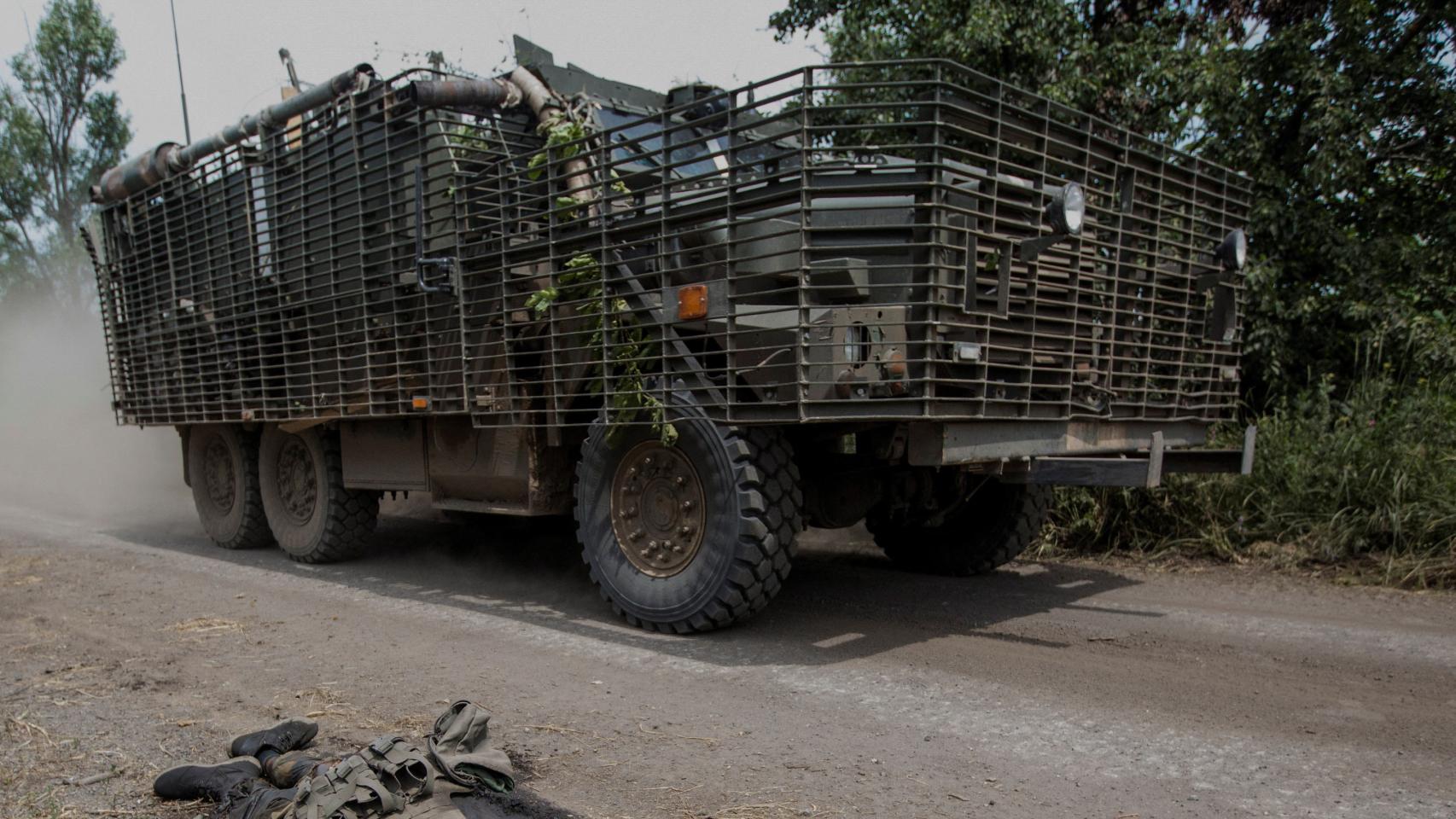 Un vehículo ucraniano pasa ante el cadáver de un soldado ruso en Donetsk