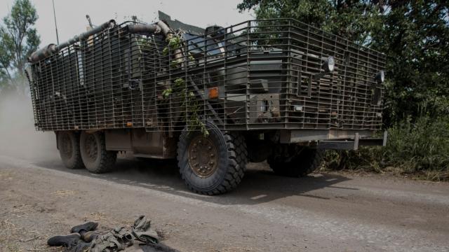 Un vehículo ucraniano pasa ante el cadáver de un soldado ruso en Donetsk