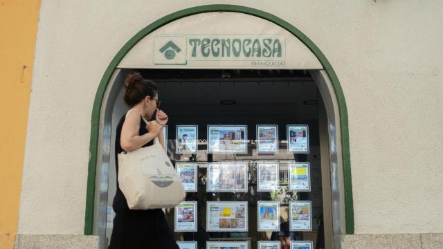 Una mujer pasa ante el escaparate de una inmobiliaria.
