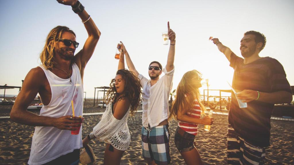 Un grupo de jóvenes bailando en la playa.