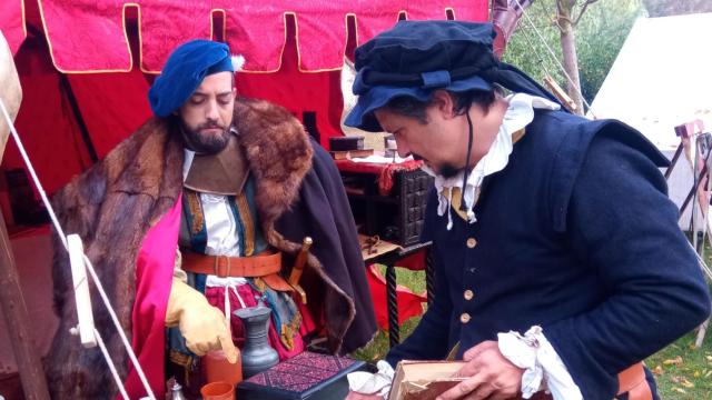 Dos hombres de la corte del emperador Carlos V despachan durante la celebración del mercado en Valcescapa