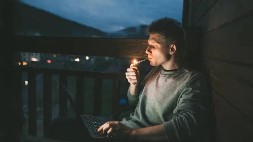 Hombre fumando en la terraza de su casa