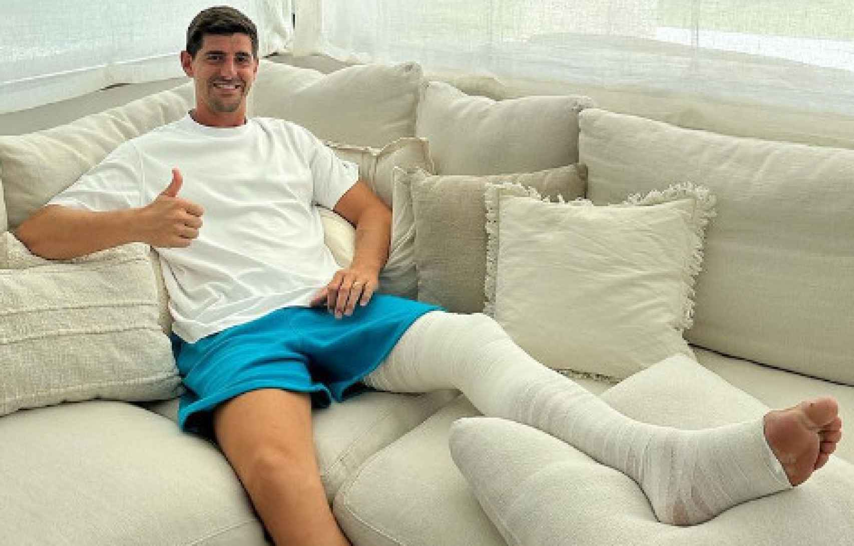 Courtois posa con su pierna izquierda totalmente vendada.
