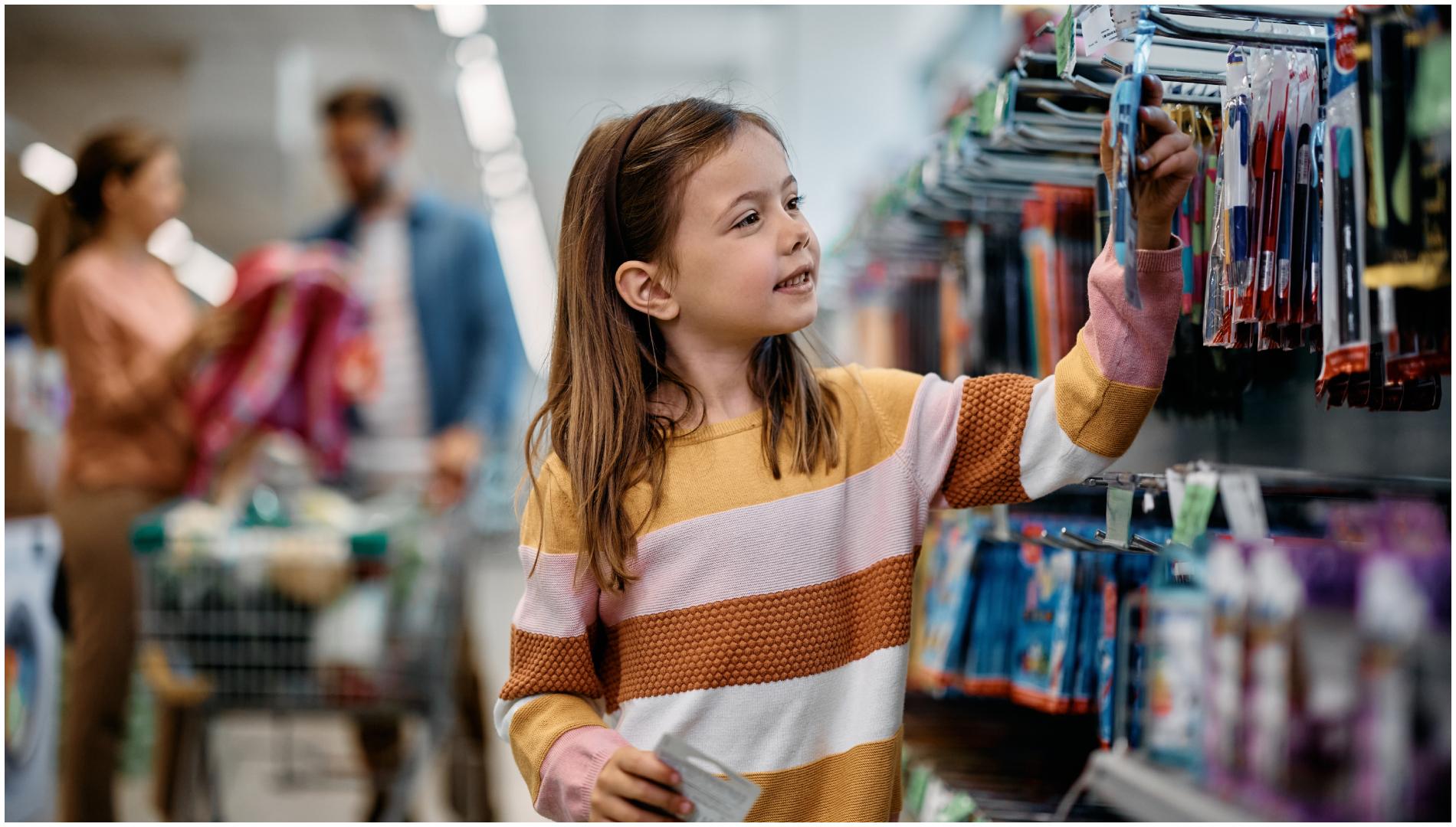 Una niña mira material de papelería en un establecimiento