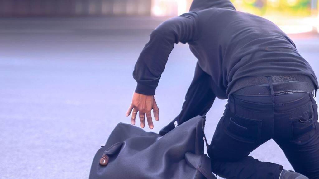 Imagen de un ladrón robando un bolso