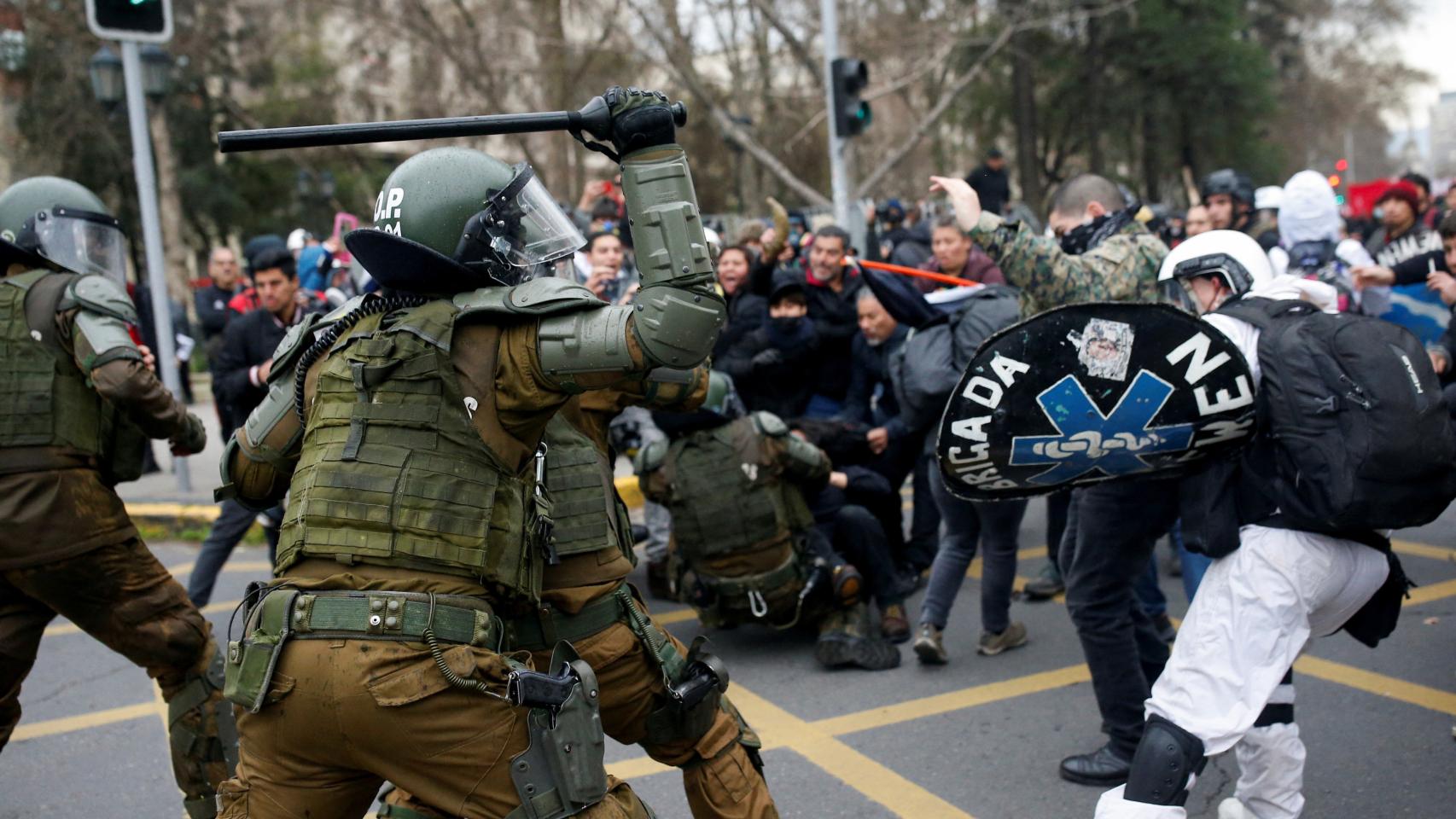 Varios manifestantes chocan con los antidisturbios durante una manifestación en Santiago de Chile.