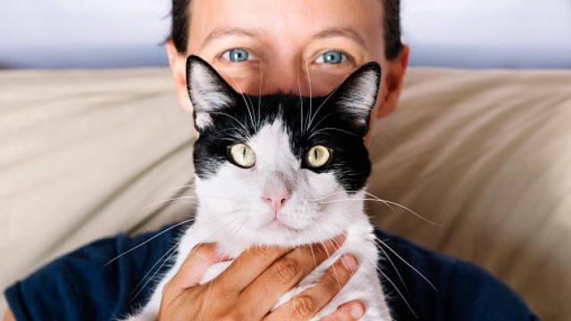 Una imagen de una mujer y su gato mirando a cámara.