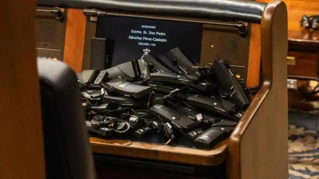 Imagen de los pinganillos de los diputados de Vox en el escaño de Pedro Sánchez