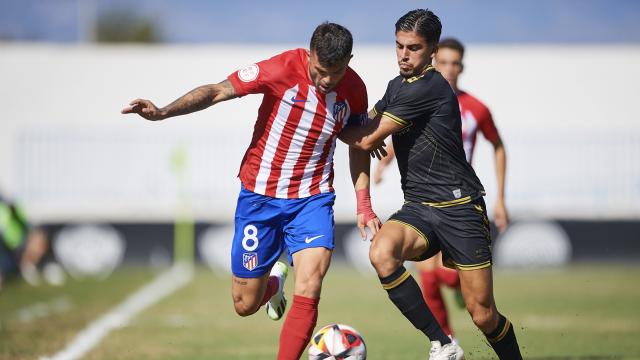 Un jugador del Atleti disputa el balón con uno del Intercity.