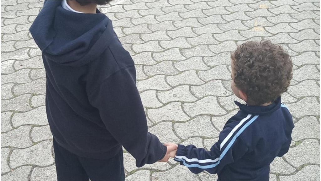 Martín (derecha) agarrado de la mano por su hermano