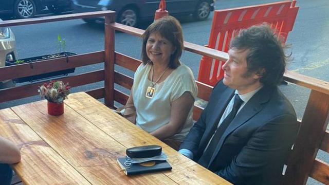 Patricia Bullrich y Javier Milei comparten banco en una terraza.