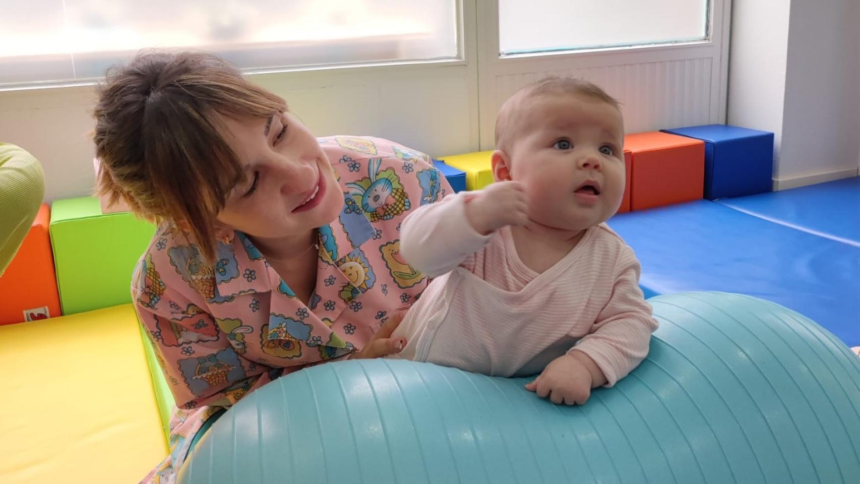 La fisioterapeuta pediátrica Belén Concejero con uno de sus pacientes.