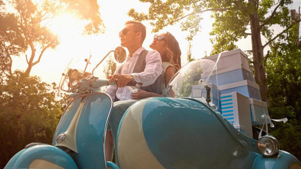 Una pareja saliendo de su boda con cajas y regalos