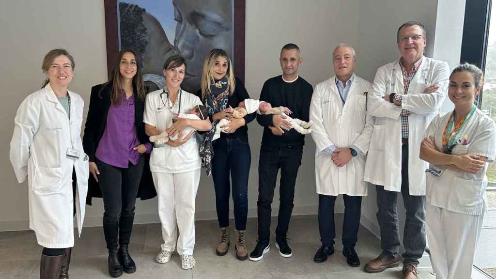 Parte del equipo médico junto a los padres y los tres pequeños.