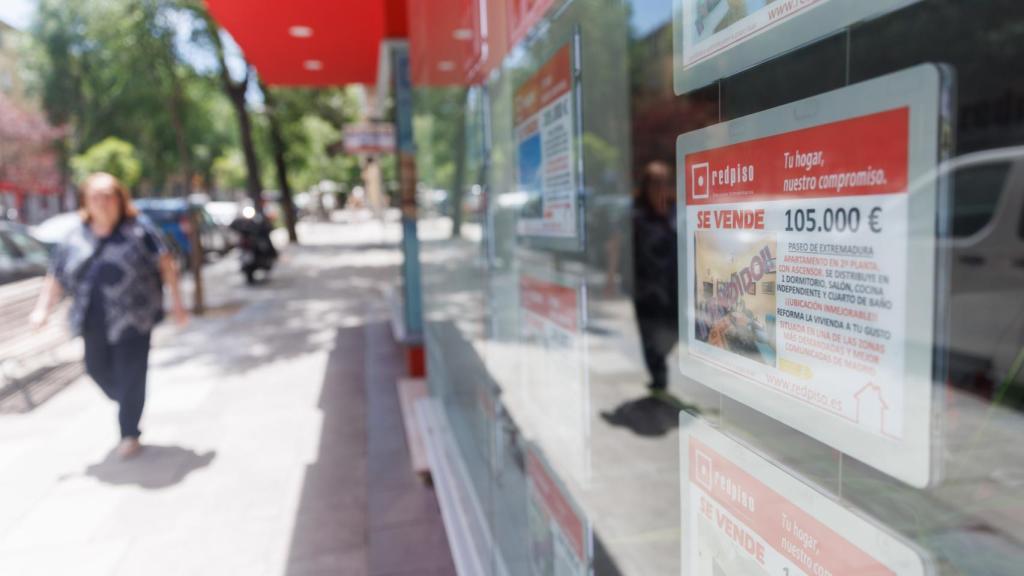 Cartel de una vivienda en venta en la oficina de una inmobiliaria.