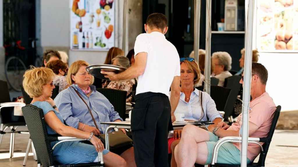 Un camarero atiende una mesa.