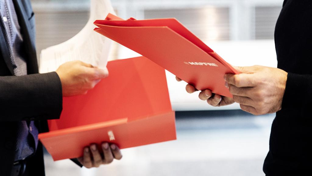 Un comercial explica el plan de pensiones a un cliente.