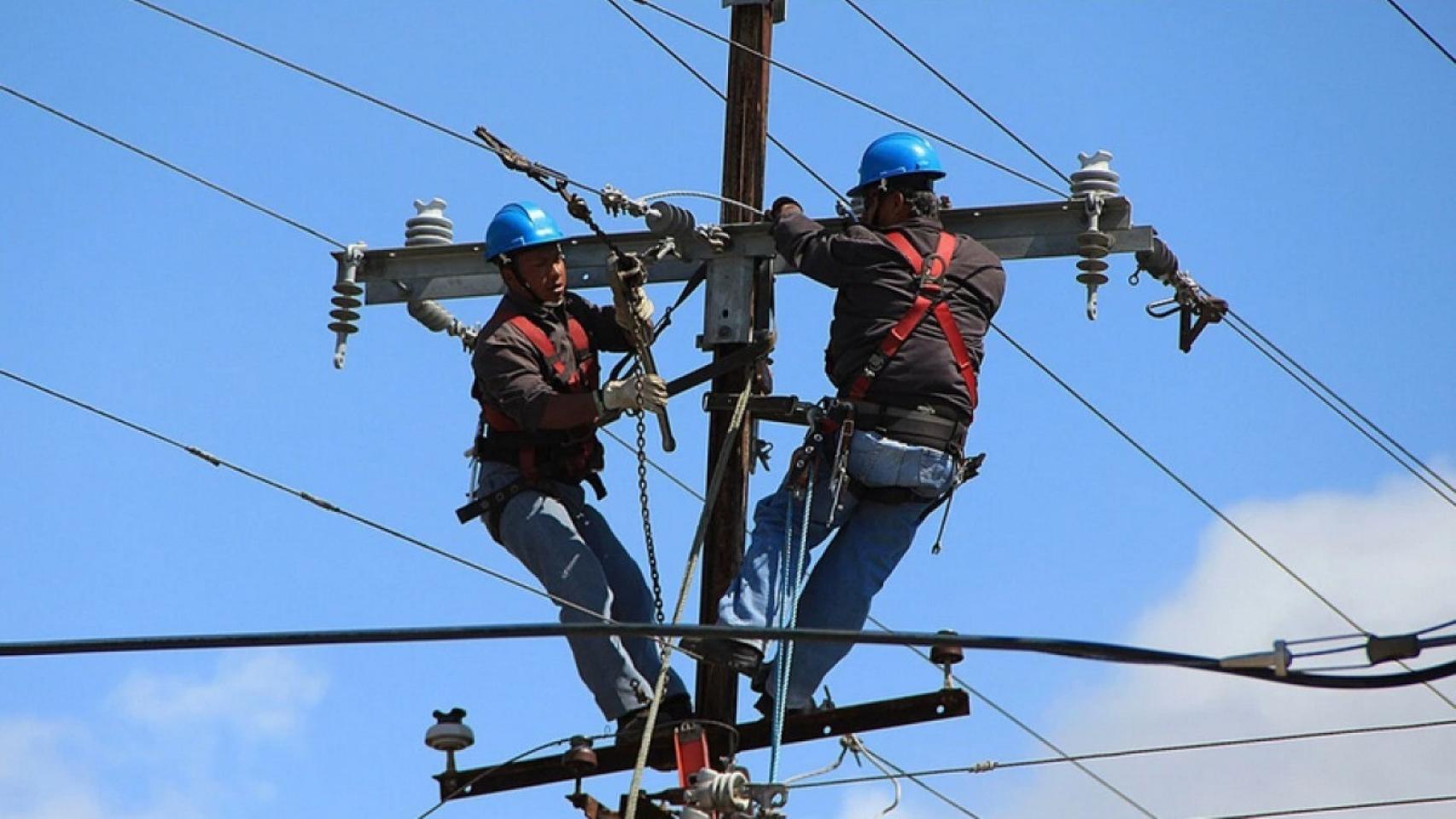 Trabajadores en un poste de telefonía en un imagen de archivo.