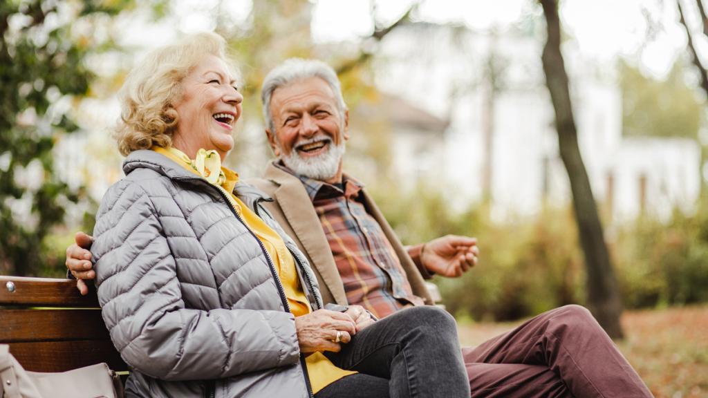 Una pareja de ancianos disfruta de un momento de diversión en un parque.