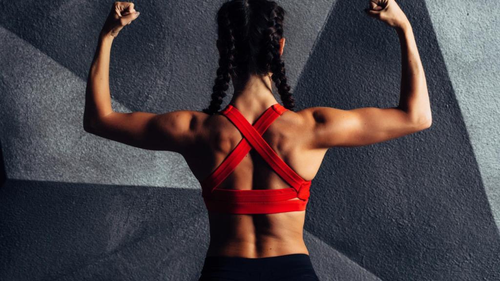 Imagen de una mujer de espaldas levantando los brazos