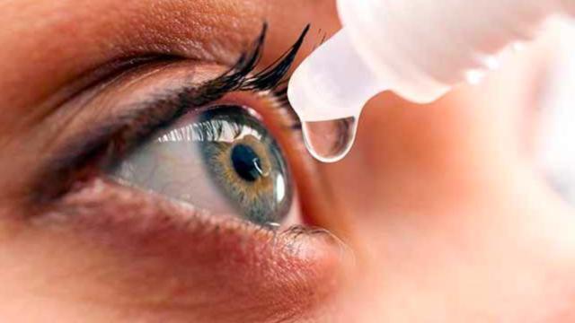 Una joven echándose un colirio en el ojo.