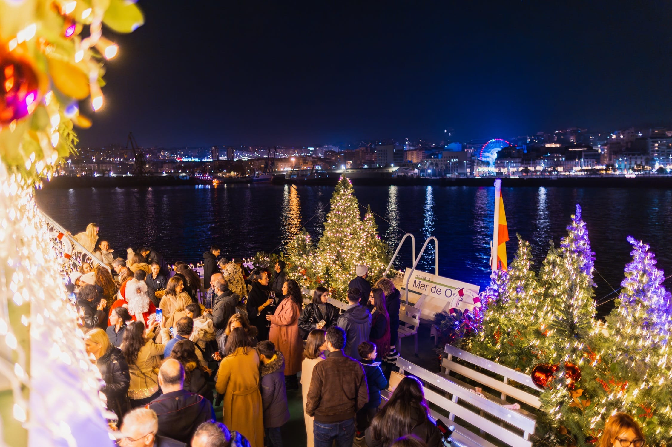 Pasajeros disfrutando del conocido como Barco do Nadal en la ría de Vigo.